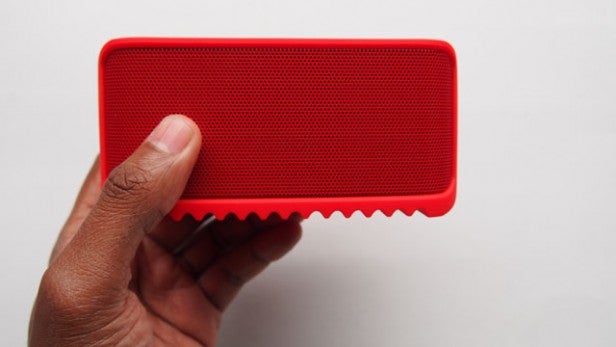 Hand holding a red Jabra Solemate Mini speaker.
