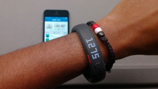 Wearable fitness tracker on wrist with smartphone in background