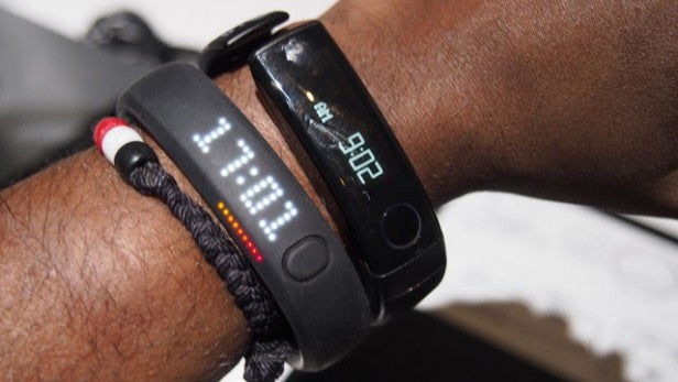 Person wearing LG LifeBand Touch on wrist displaying time.Person wearing LG LifeBand Touch displaying time and fitness data.