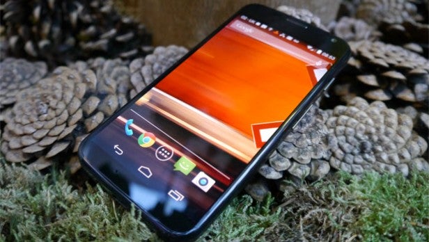 Smartphone with Android 4.4 on screen among pine cones.