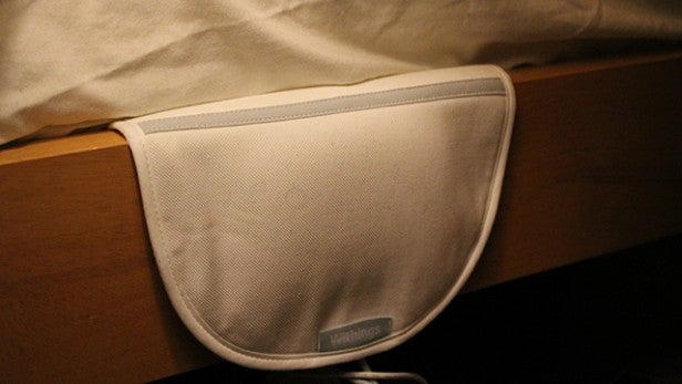 Withings Aura sleep monitor under a bedsheet.