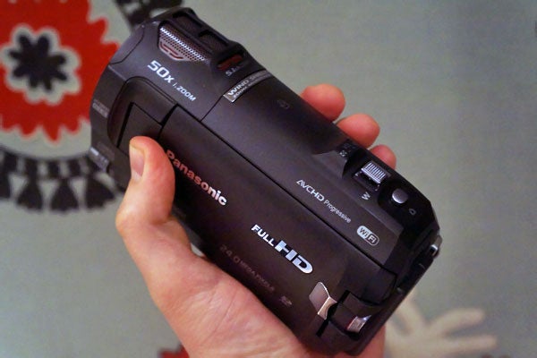 Hand holding Panasonic HC-W850 camcorder with Full HD label.