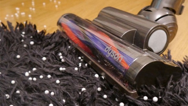 Dyson vacuum cleaner head cleaning a shaggy rug.