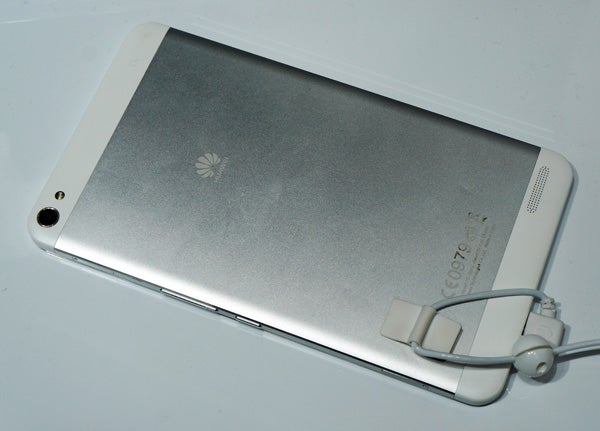 Huawei MediaPad X1 tablet with earphones on white surface.
