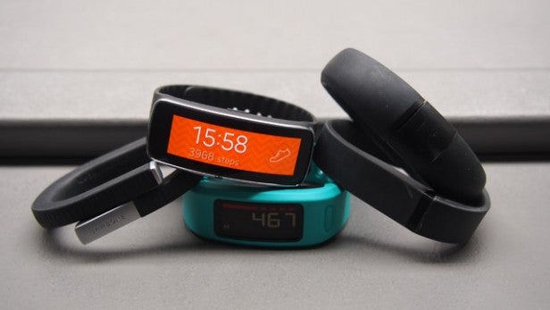 Fitness trackers with displayed step counts on a surface.