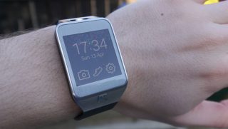 Samsung Gear 2 smartwatch on a person's wrist displaying time.