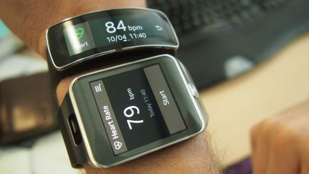 Two smartwatches on wrist displaying heart rate monitor feature.