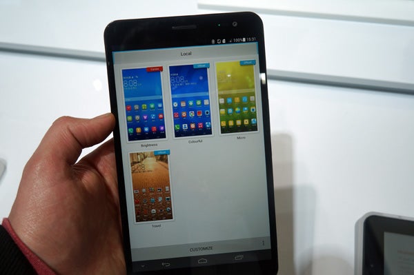 Hand holding Huawei MediaPad X1 displaying home screen.