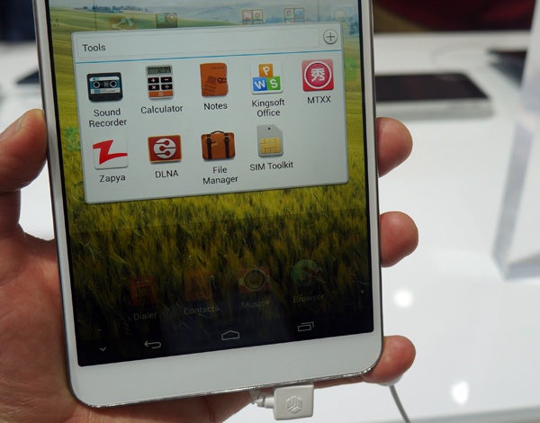Huawei MediaPad X1 displaying home screen with apps in hand.