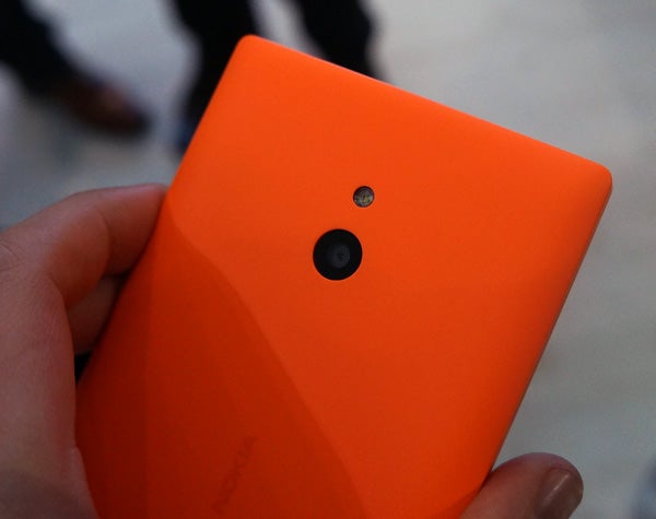 Close-up of a person holding an orange Nokia XL smartphone.