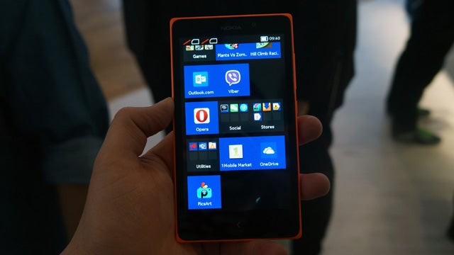 Hand holding a Nokia XL smartphone displaying apps on screen.