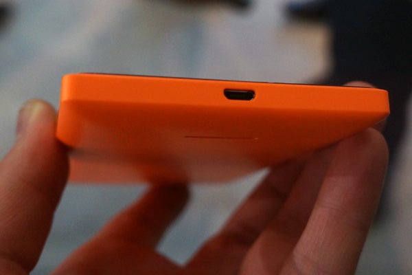 Close-up of Nokia XL's orange side profile with volume buttonsClose-up of a person holding an orange Nokia XL smartphone.