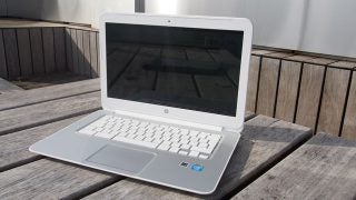 HP Chromebook 14 displayed on wooden surface outdoors.
