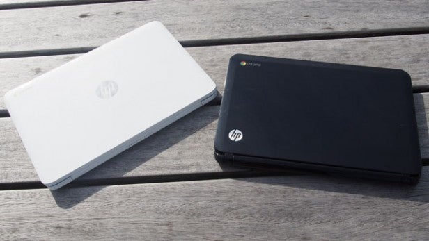 Two HP Chromebook 14 laptops on a wooden surface.