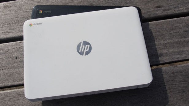 HP Chromebook closed on wooden surface in daylight.