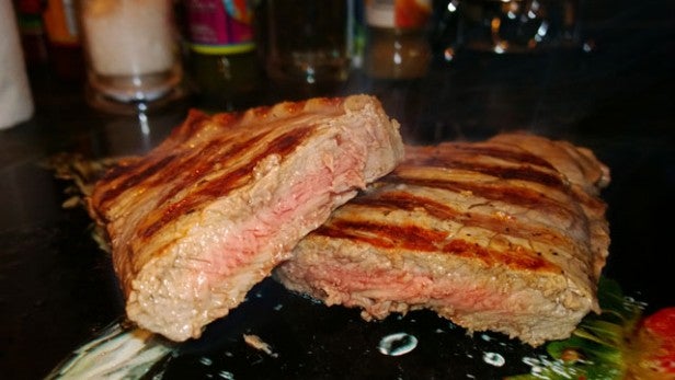 Grilled steak cut open showing medium-rare cooking level.