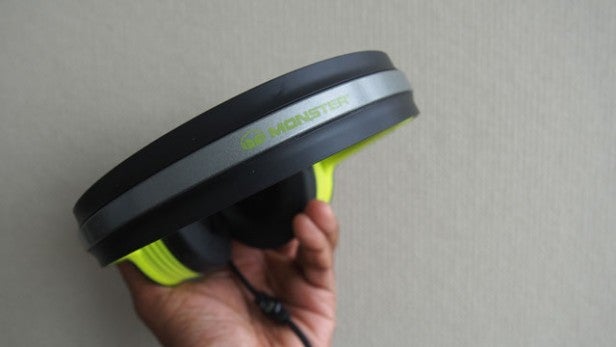 Hand holding a Monster iSport Freedom wireless headphone.
