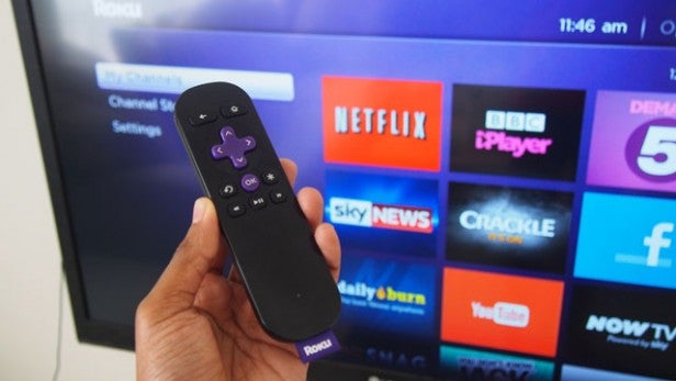 Roku Streaming Stick remote with TV interface in background.