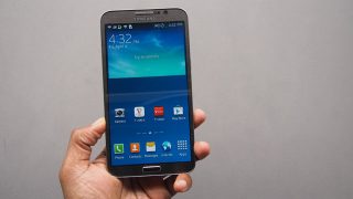 Hand holding a Samsung Galaxy Round smartphone.