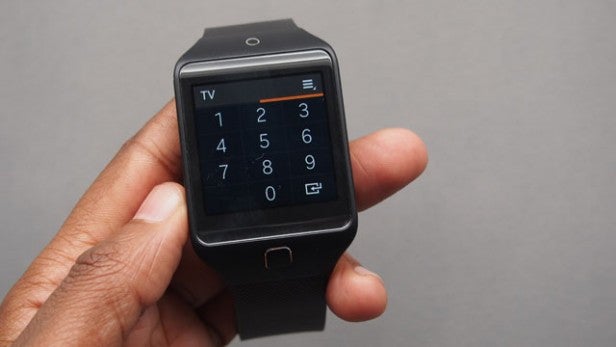 Smartwatch on hand displaying keypad app for numeric input.