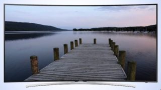 Samsung UE55H8000 curved TV displaying a serene lake dock scene.