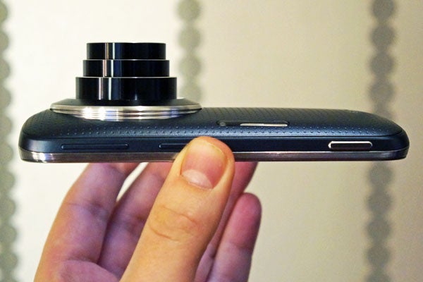 Samsung Galaxy K Zoom held in hand showing lens and thickness.