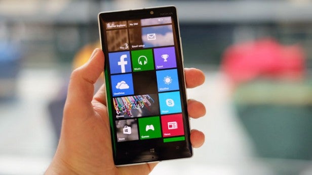 Hand holding a Nokia Lumia 930 displaying apps.