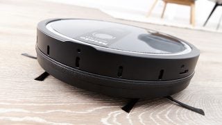 Miele Scout RX1 robotic vacuum cleaner on wooden floor.