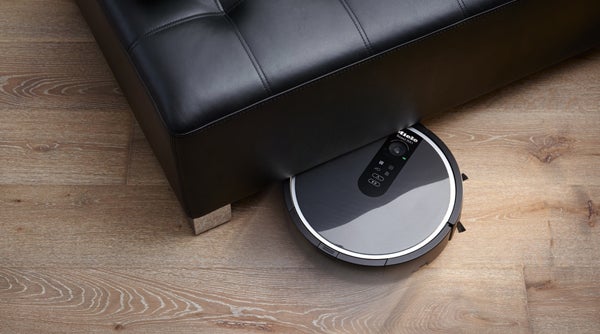 Miele Scout RX1 robot vacuum cleaning under a sofa.