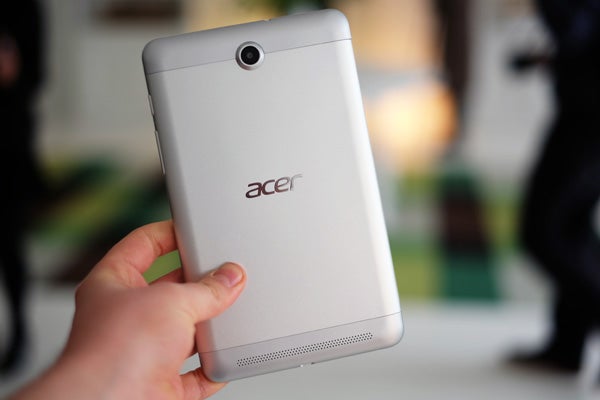 Hand holding Acer Iconia Tab 7 showing rear camera and logo.