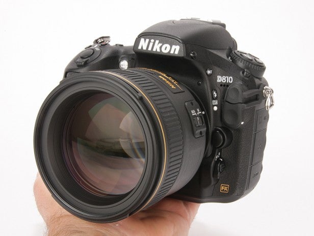 Nikon D810 camera held in hand showing lens and controls