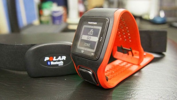Fitness watch and Bluetooth heart rate monitor on table.