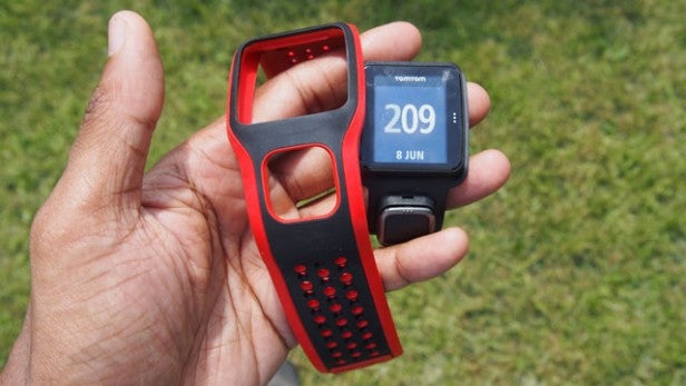 Hand holding a TomTom Runner Cardio GPS watch.