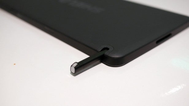 Stylus partially inserted in tablet's side slot.