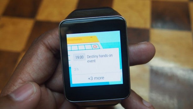 Person holding a smartwatch displaying calendar events.