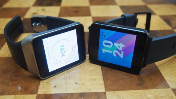 Two smartwatches on wooden surface displaying time and battery life.