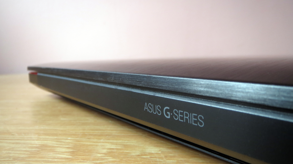 Side view of Asus G-Series laptop on a wooden surface.