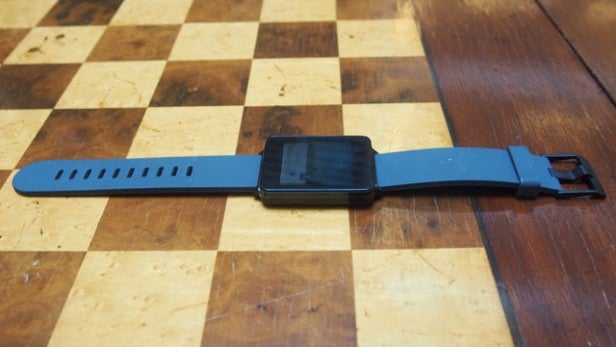 LG G Watch on a wooden chess board surface.