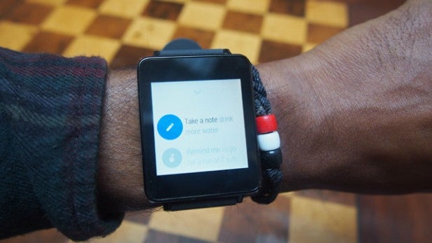 Smartwatch on wrist displaying Android Wear note-taking app.