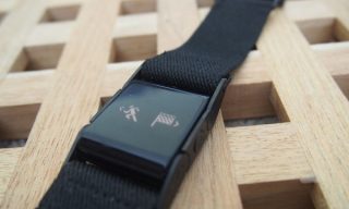 PulseOn heart rate monitor wristband on a wooden surface.