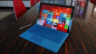 Surface Pro 3 with blue keyboard on wooden table