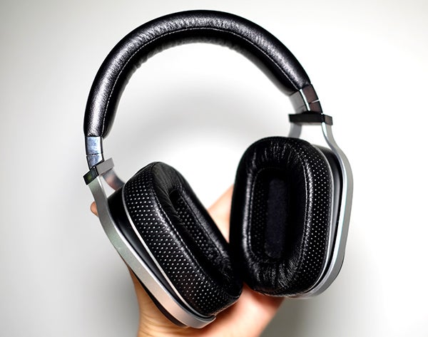 Oppo PM-1 headphones held in hand against white background