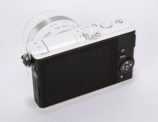 Compact camera with LCD screen and control buttons.