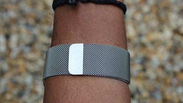 Close-up of a silver mesh Apple Watch band on a wrist.