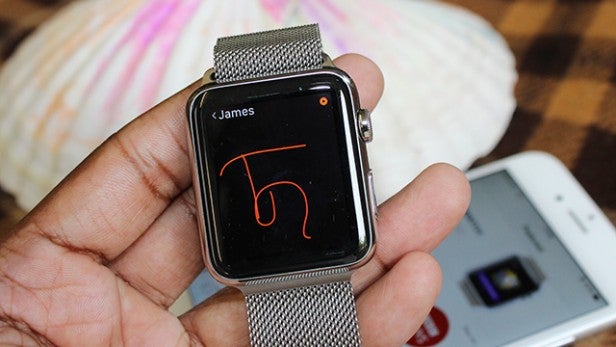 Smartwatch on wrist displaying notification with name 'James'