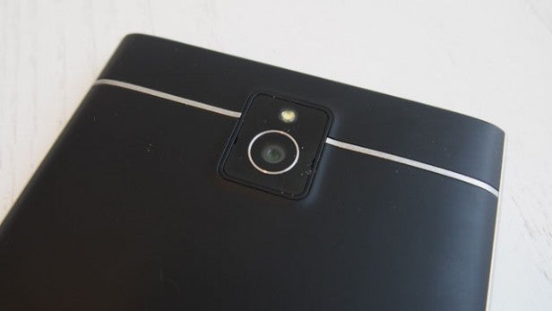 Smartphone rear camera with dual flash on black surface.