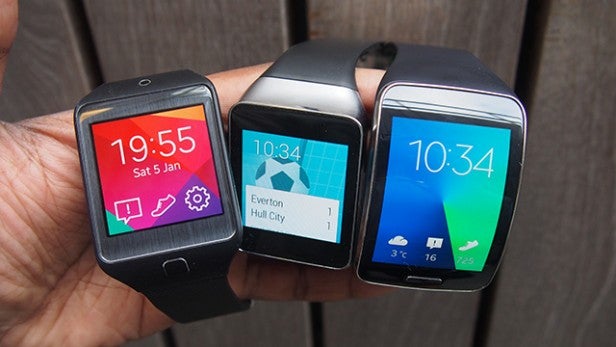Three Samsung Gear S smartwatches with different watch faces.