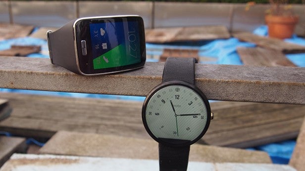 Smartwatch and smartphone on a wooden surface.
