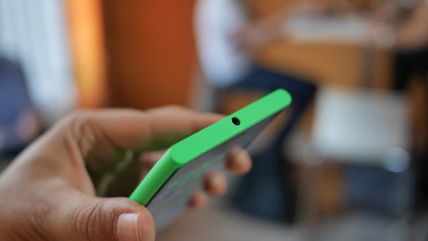 Hand holding a green Nokia Lumia 735 smartphone.
