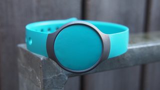 Misfit Flash fitness tracker in turquoise on concrete ledge.